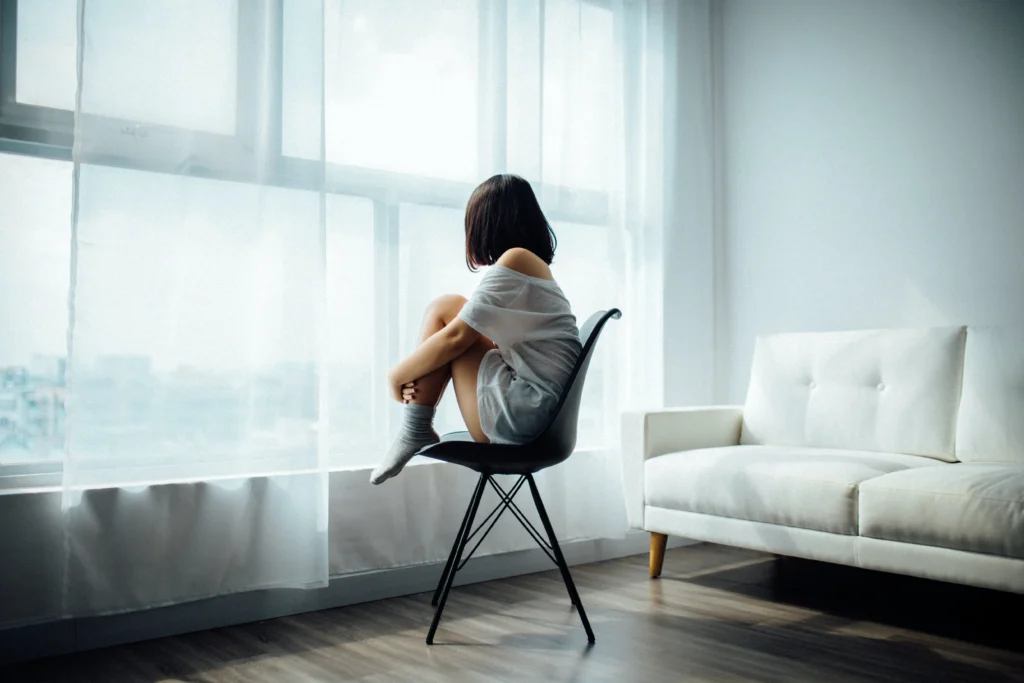 frau-stuhl-fenster-vorhaenge-vorhang-sofa-blick-nach-draussen