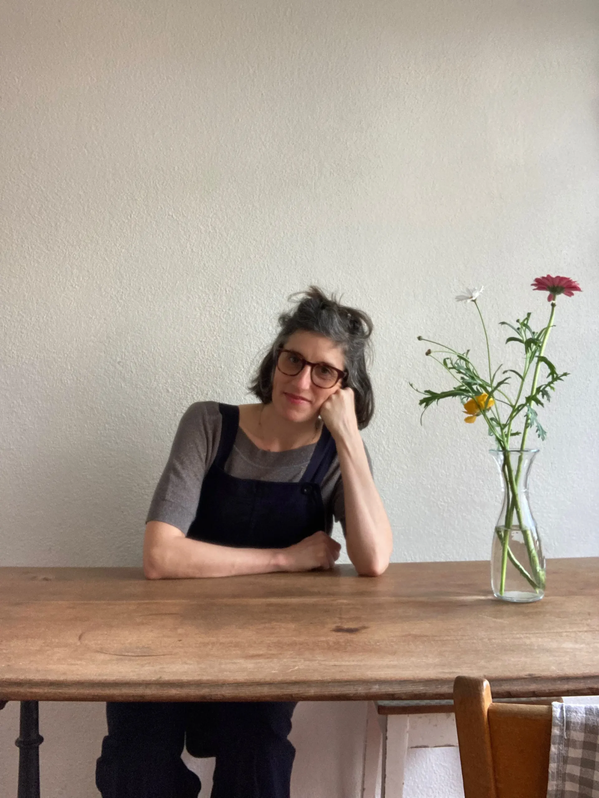 frau-ellbogen-holztisch-blumen