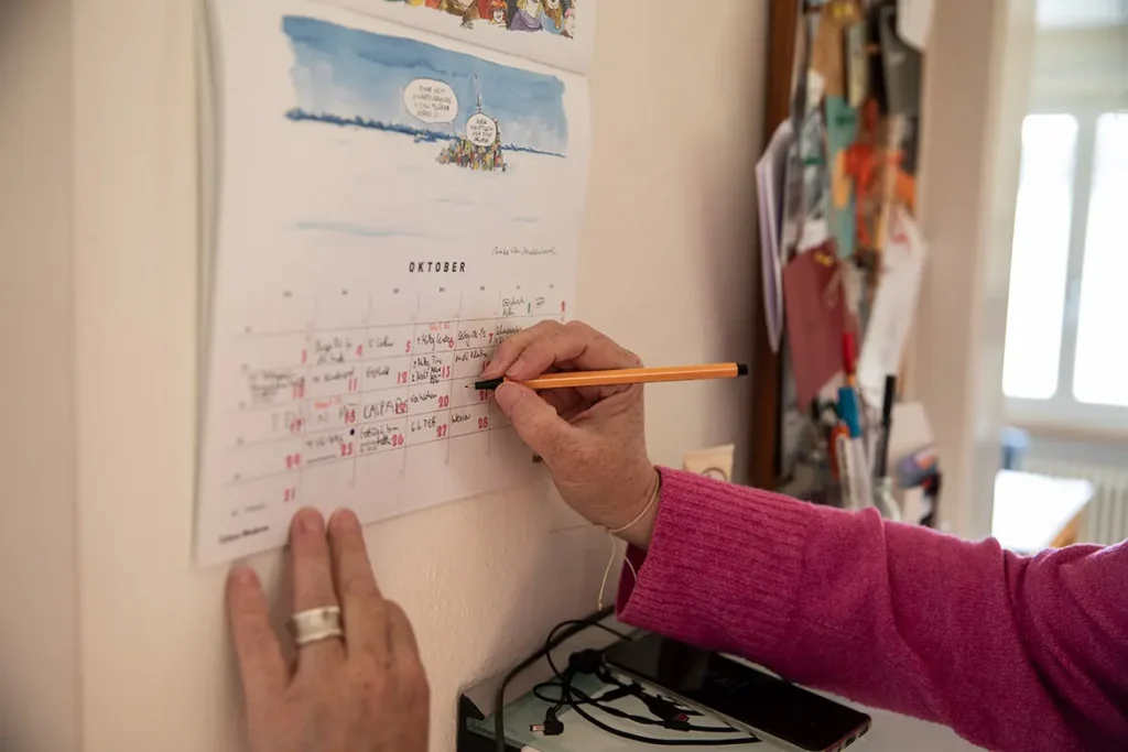 Frau-hand-wand-kalender-schreiben