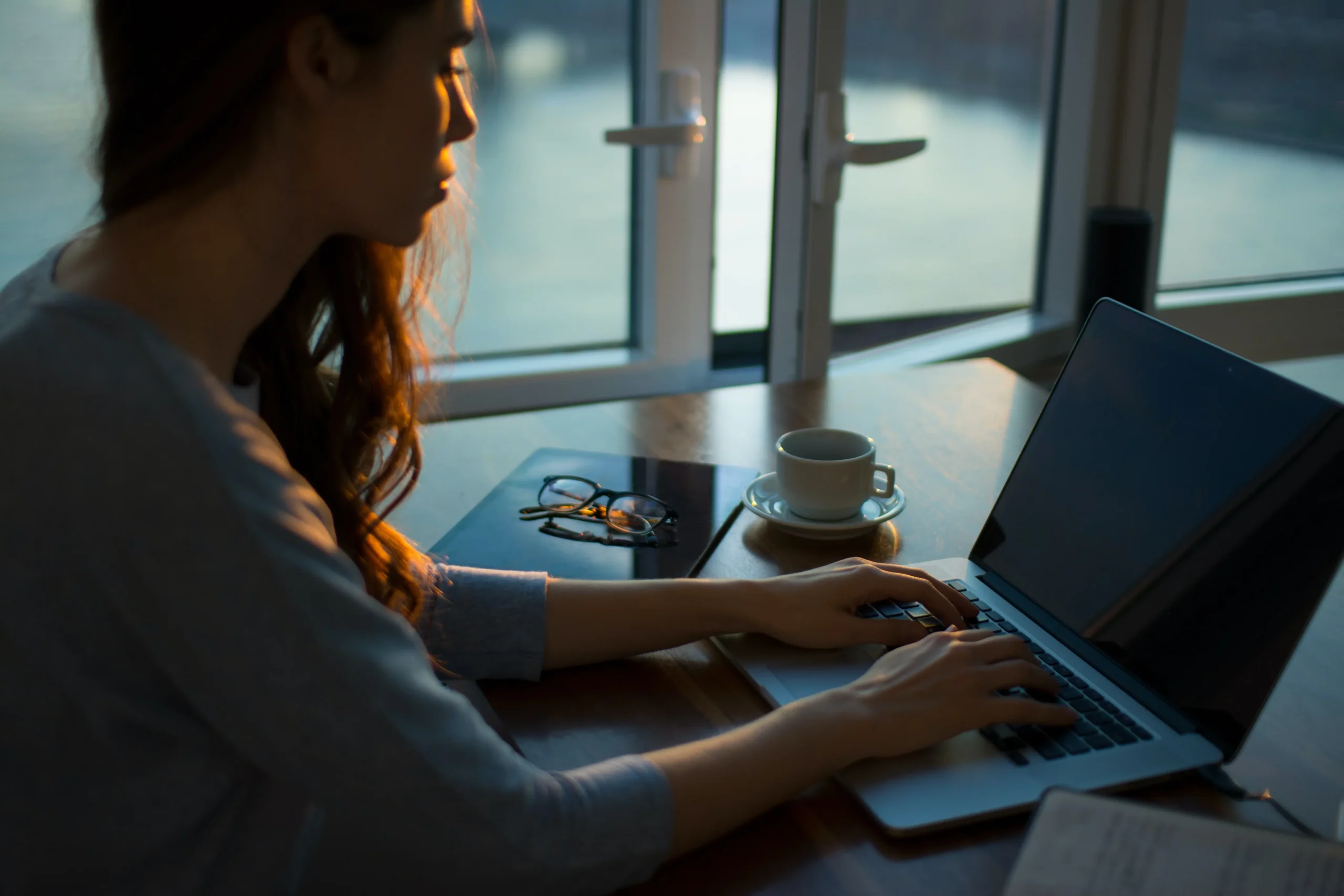 frau-laptop-fenster-offen-brille-kaffee-tasse