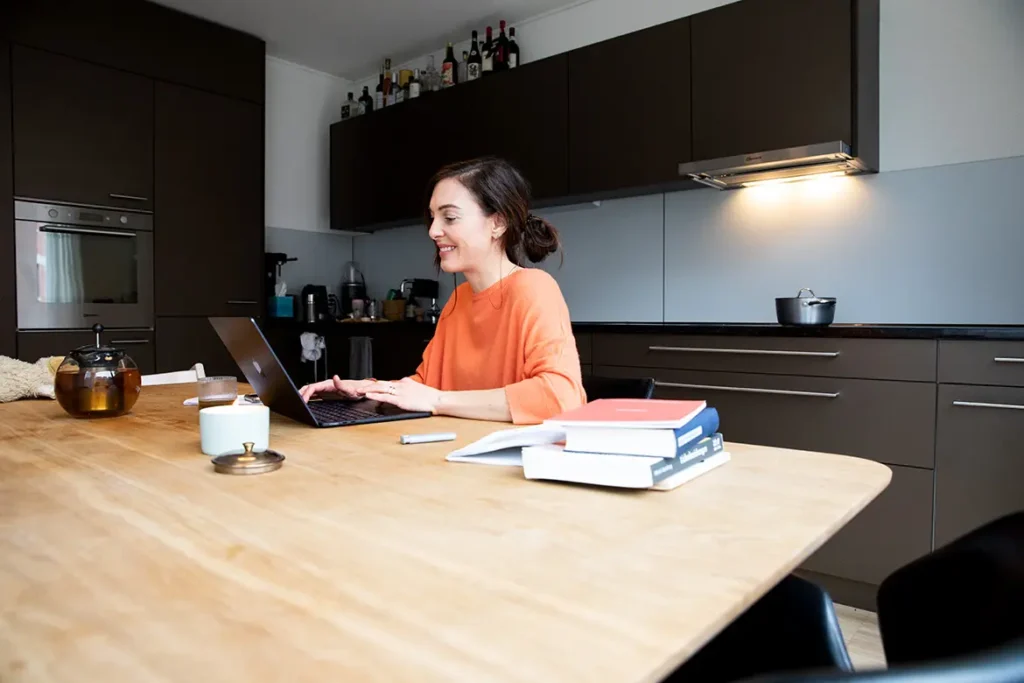 frau-küchentisch-küche-schwarz-laptop-tee-bücher