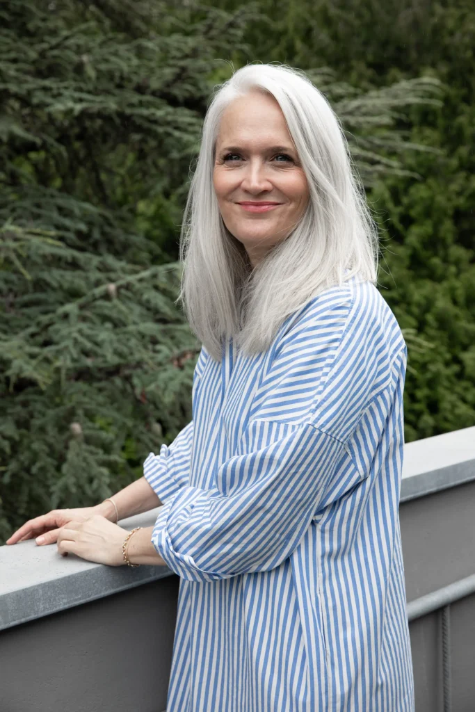 frau-weisse-haare-gestreiftes-kleid-hellblau-baum