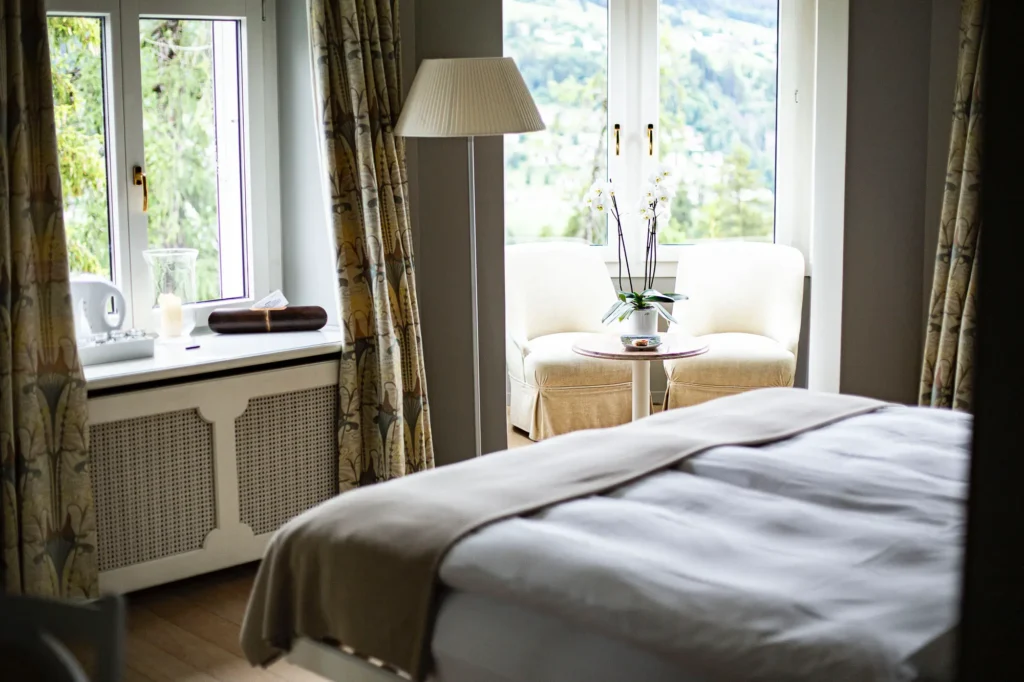 hotelzimmer-hotelbett-lampe-vorhang-aussicht-wald