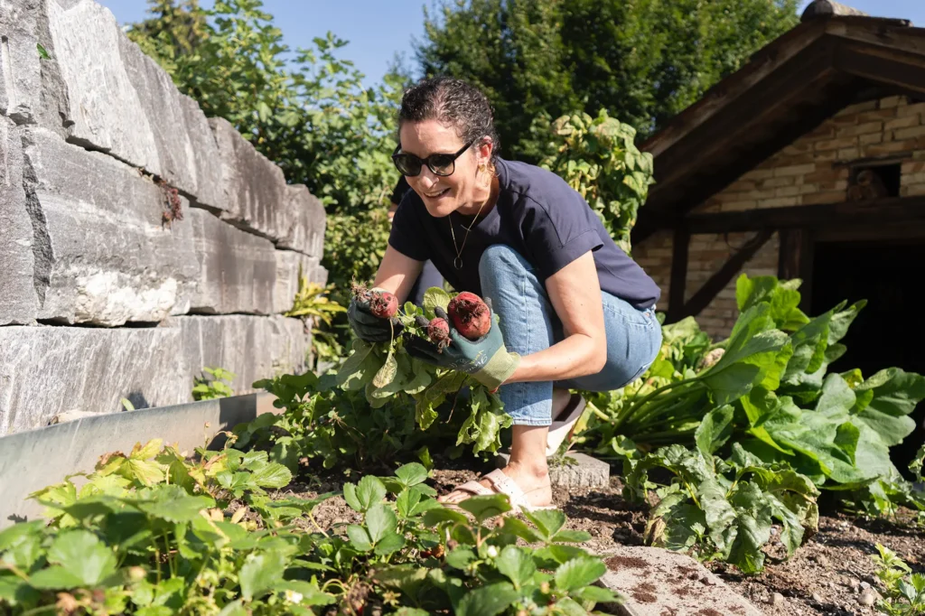 frau-schwarze-haare-gartenarbeit-knollen-erde-handschuhe-gemuese