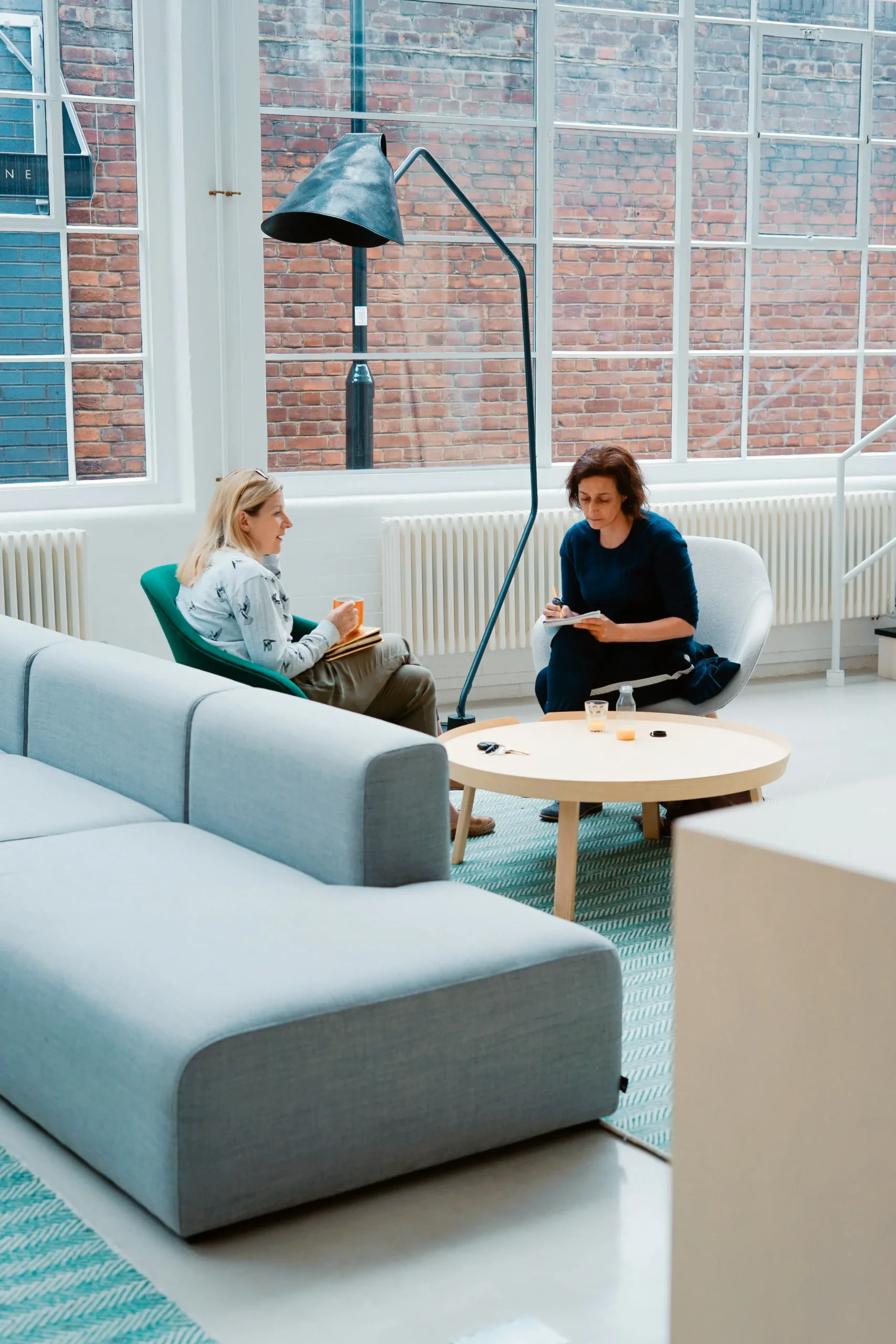 zwei-frauen-business-schreiben-fenster-backstein
