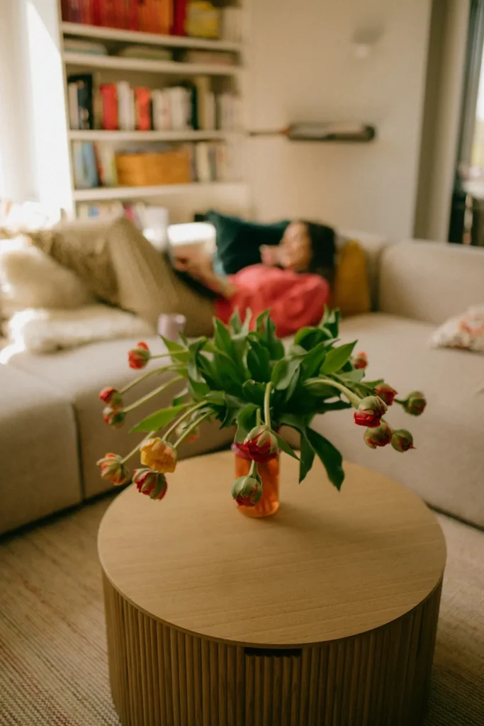 blumenstrauss-verwelkt-wohnzimmer-hintergrund-verschwommen-frau-liest