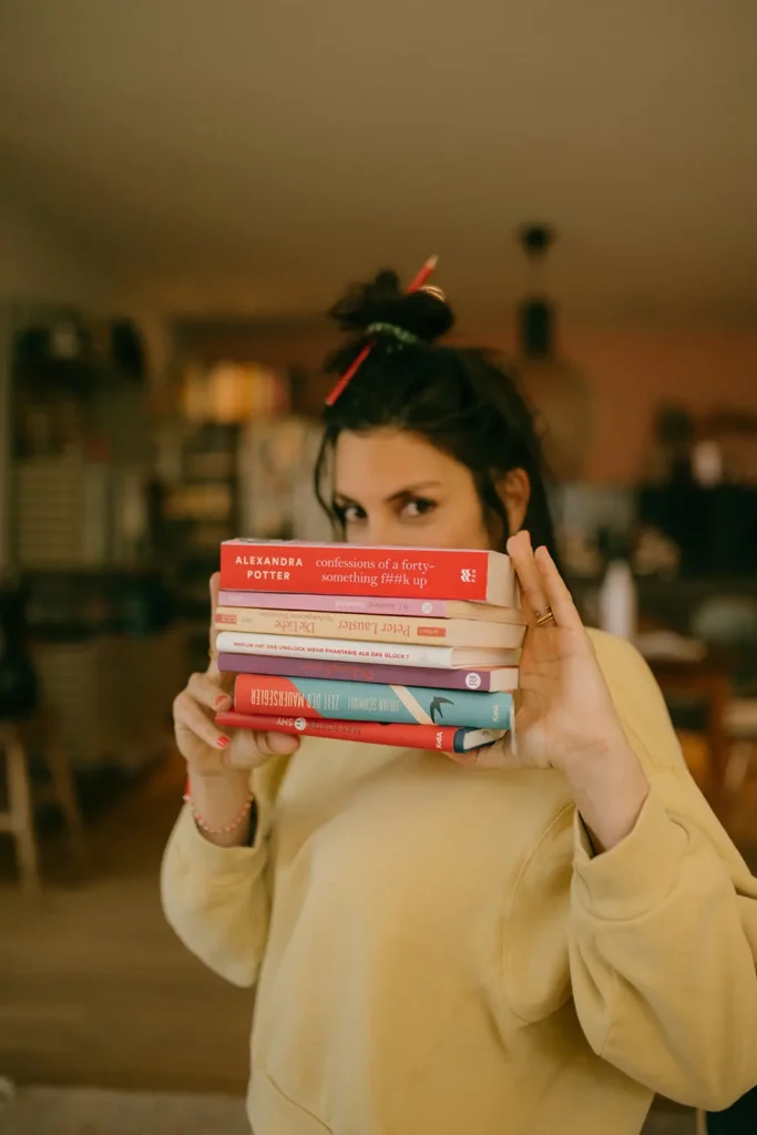 frau-gelber-pullover-bleistift-im-haar-dutt-bücher