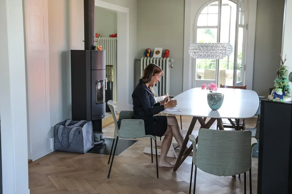 frau-blaues-kleid-esszimmer-tisch-blume-cheminee-lampe