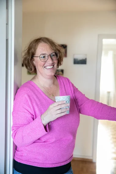 frau-tuerrahmen-tasse-becher-pink-pullover-rote-haare