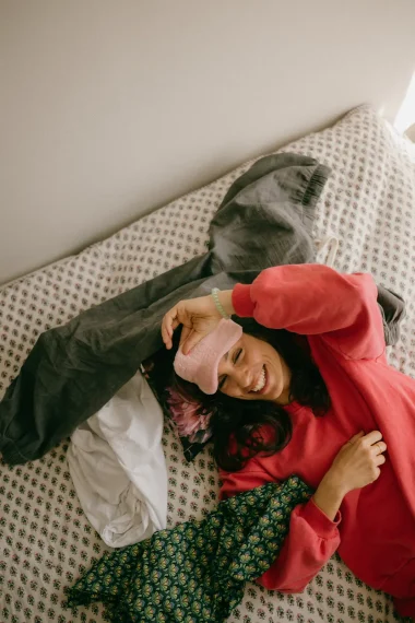 frau-schlafmaske-rosa-bett-liegen-unordnung-wäsche