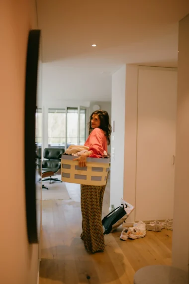 frau-wäschezeine-lachen-unordnung-parkettboden-wohnung-eames