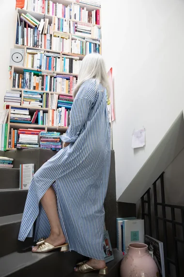 frau-gestreiftes-kleid-buecherregal-treppe